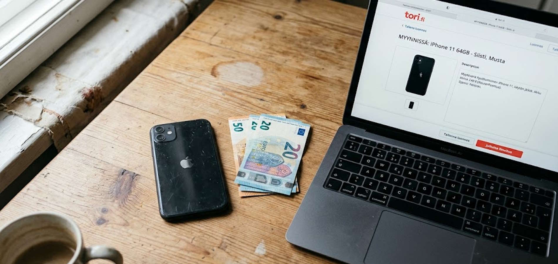 Käytetty iPhone, käteistä euroseteleitä ja Tori.fi-tyylinen ilmoitus rinnakkain pöydällä